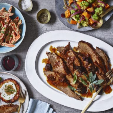 Tablescape of beef brisket, romanesco, carrots and latkes
