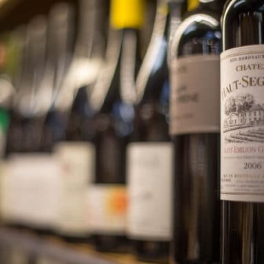 Close up of wine bottle on a shelf with shallow depth of field