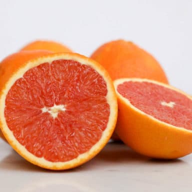 Four cara cara oranges, two in the front halved