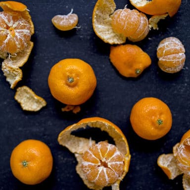 Kishus in various stages of unpeeling on a dark surface