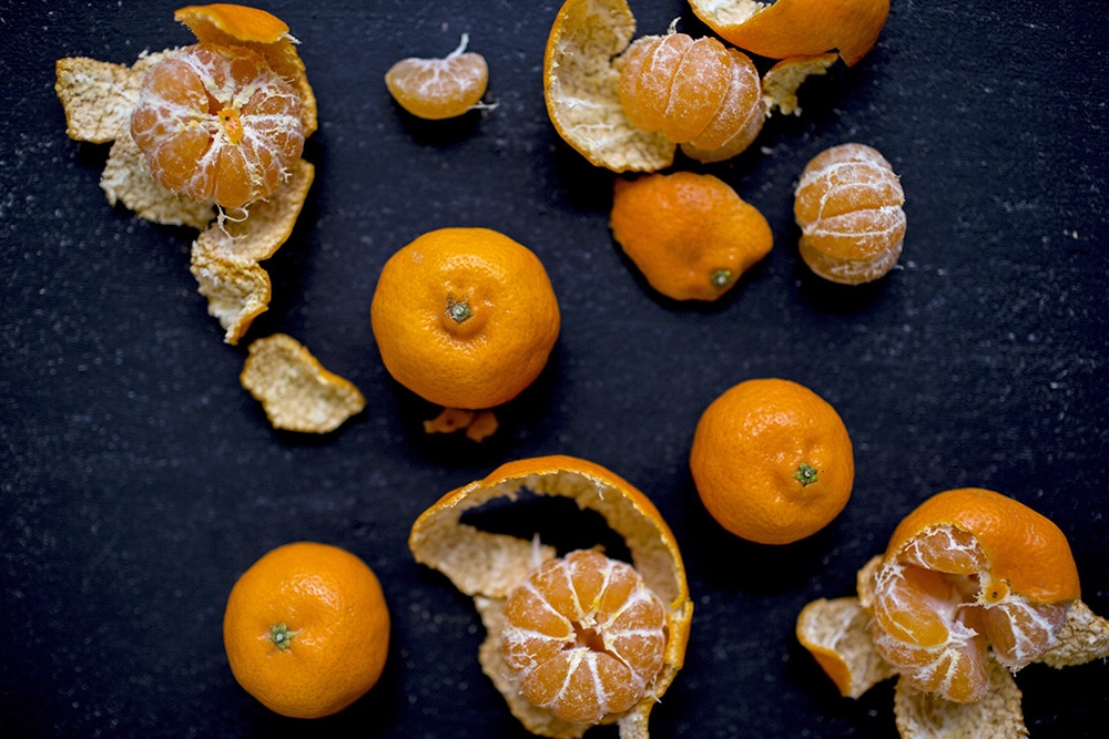 Kishus in various stages of unpeeling on a dark surface