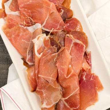 A pile of shaved ham on a plate