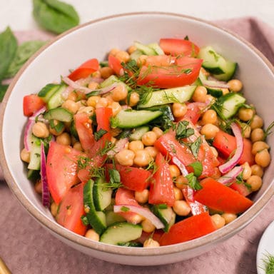 Chickpea Salad with a serving spoon and herbs