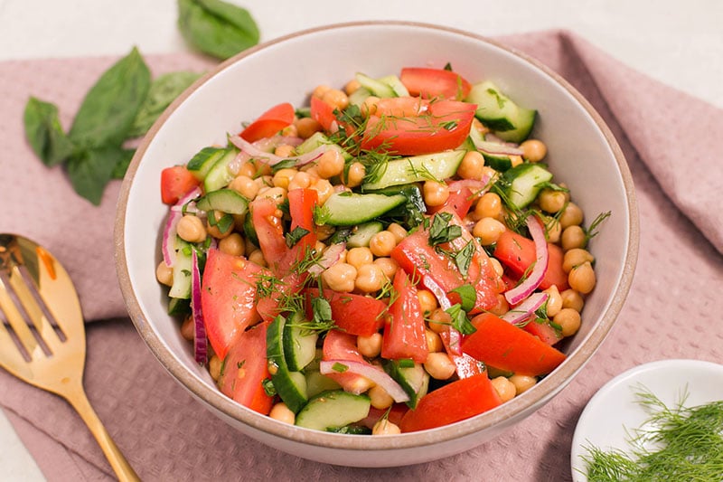 Chickpea Salad with a serving spoon and herbs