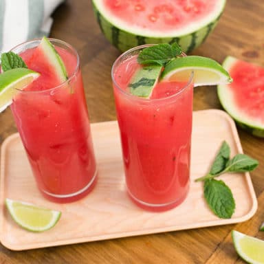 Two glasses of Watermelon Agua Fresca with watermelon wedges off to the side