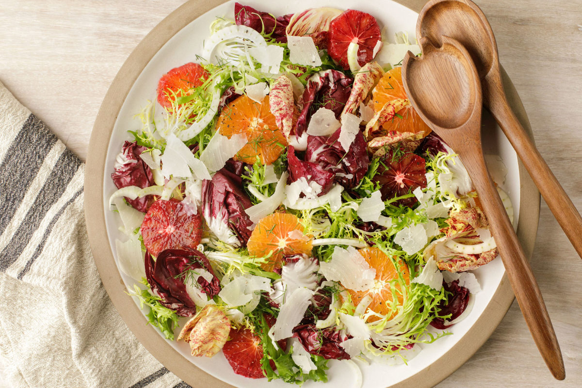 A large bowl of salad with serving implements