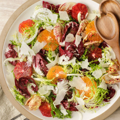 A large bowl of salad with serving implements