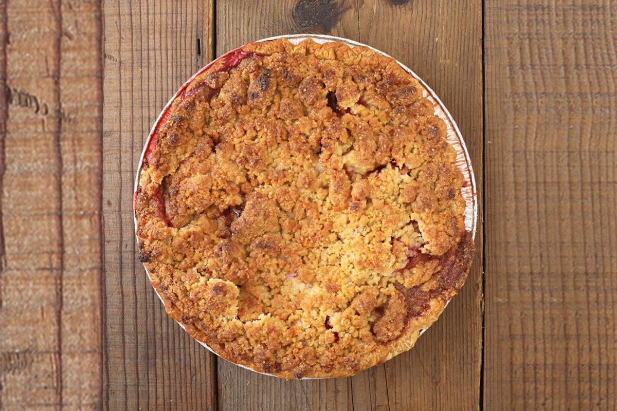 Whole pie shot from above with crumble and compote peeking out