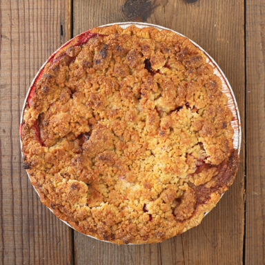 Whole pie shot from above with crumble and compote peeking out