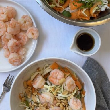 Two bowls of rice noodle salad with shrimp and spring veggies.