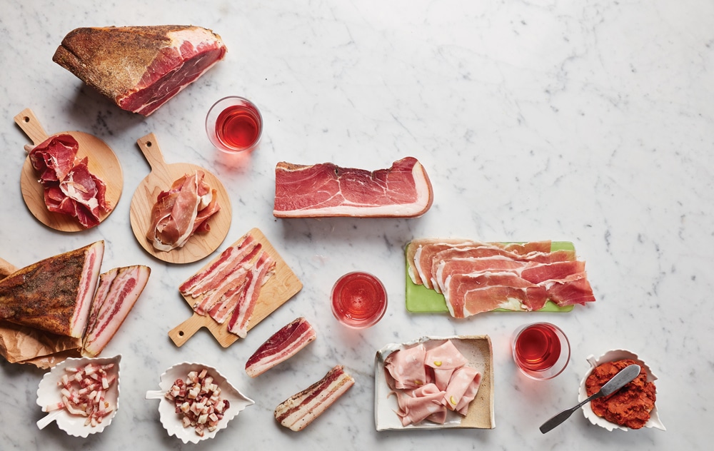 A Marble Counter Arranged With Prosciutto, Pancetta, Mortadella, And Other Cured Meats
