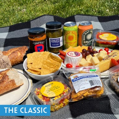 A picnic of chips, bread, corn salsa, cheese platter