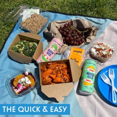 Picnic of prepare sweet potatoes, salad, beet citrus, soda, grapes