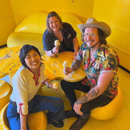 Shuggies and Bi-Rite team members holding ice cream cones sitting in yellow Cheetah room