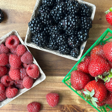Top Down Shot Of Raspberries Blackberries Strawberries Packaged On Cutting Board